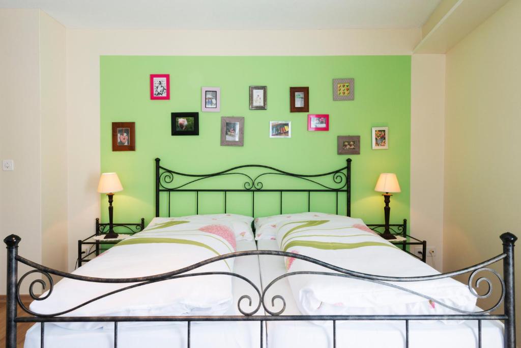 布奥克斯Hotel Sternen的绿色卧室配有一张床,墙上挂有图片