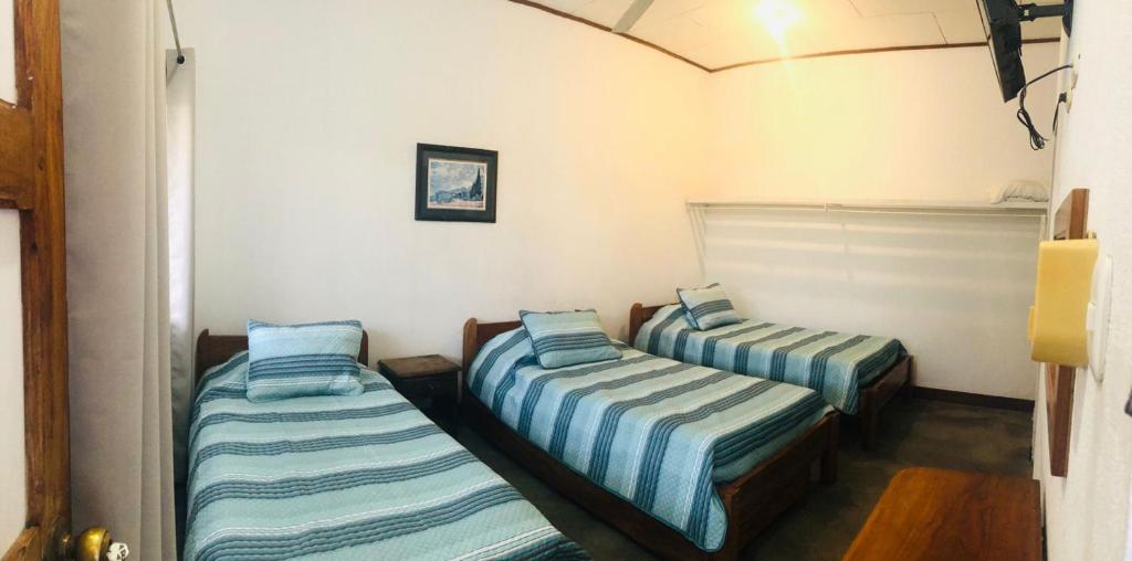 利比里亚Hotel Del Aserradero的蓝色和白色条纹间内的两张床
