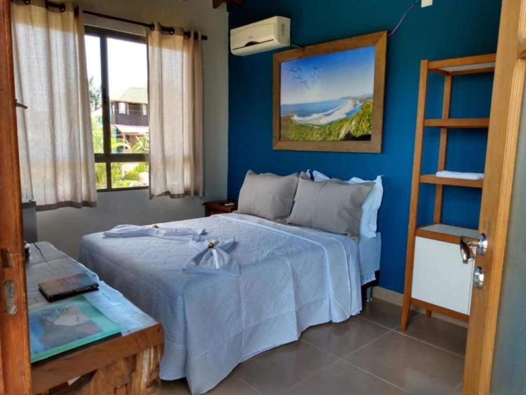 瓜尔达恩巴Essência da Guarda Surf House的一间卧室配有一张蓝色墙壁的床