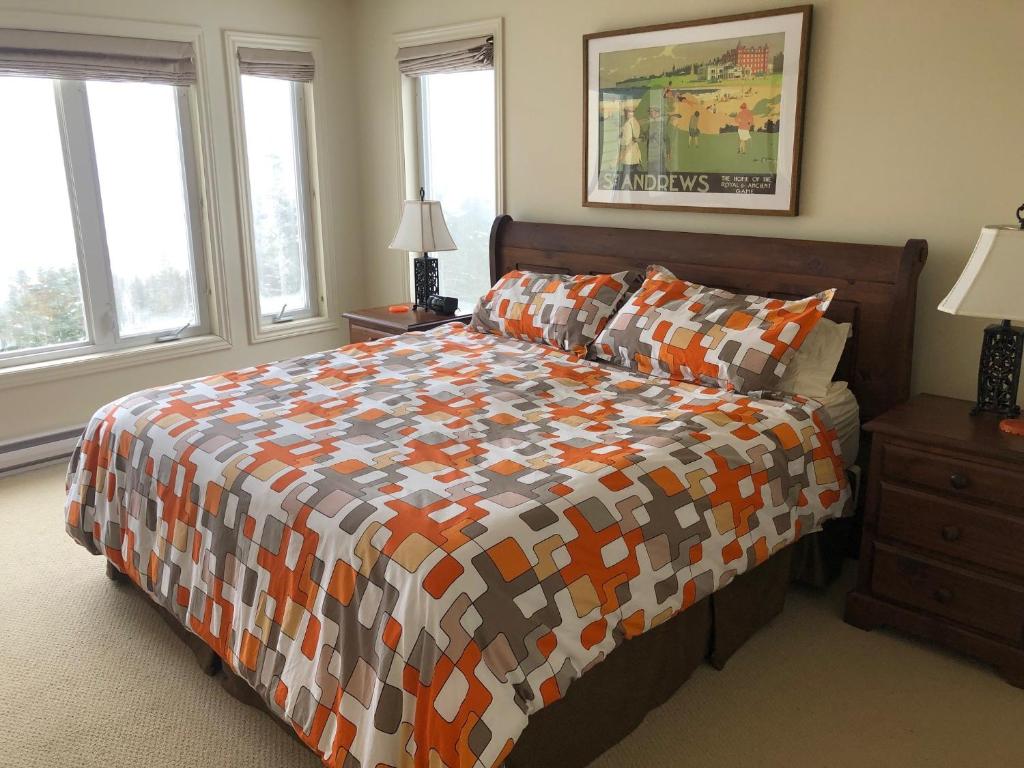 South BrookThe Thoughtful Dog Bed & Breakfast的一间卧室配有一张带色彩缤纷的被子和窗户的床。