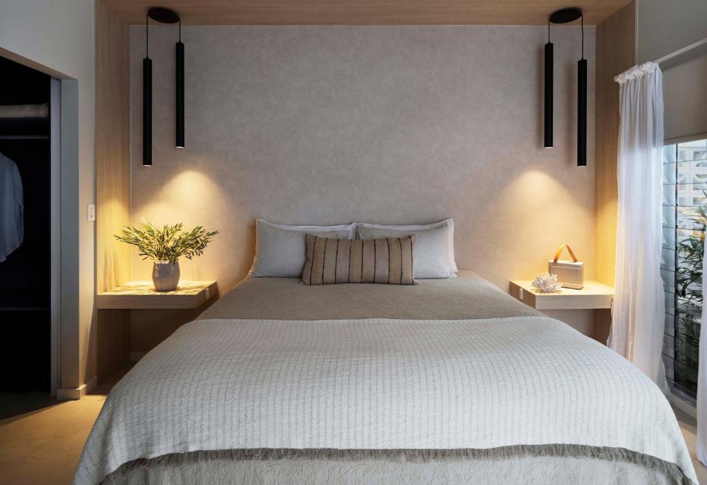 麦夸里港Tallowwood House Luxury Bed & Breakfast的一间卧室配有一张带2个床头柜的大床