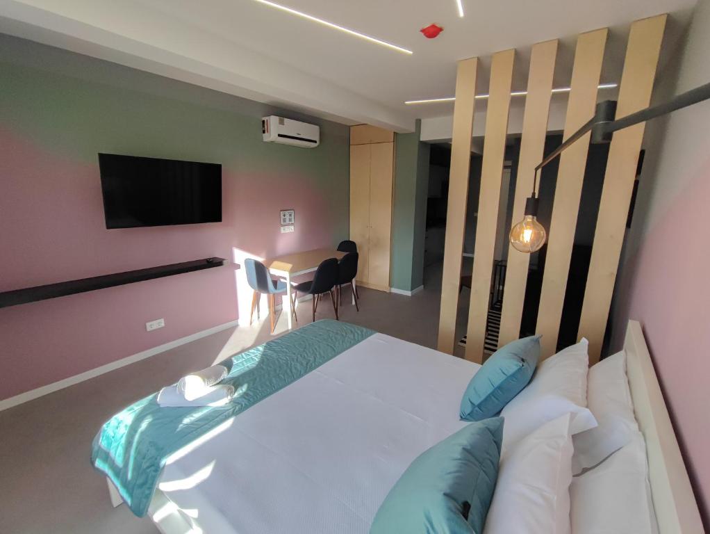 丰沙尔Social Lodge - Happiness的一间卧室配有一张床、一台电视和一张桌子
