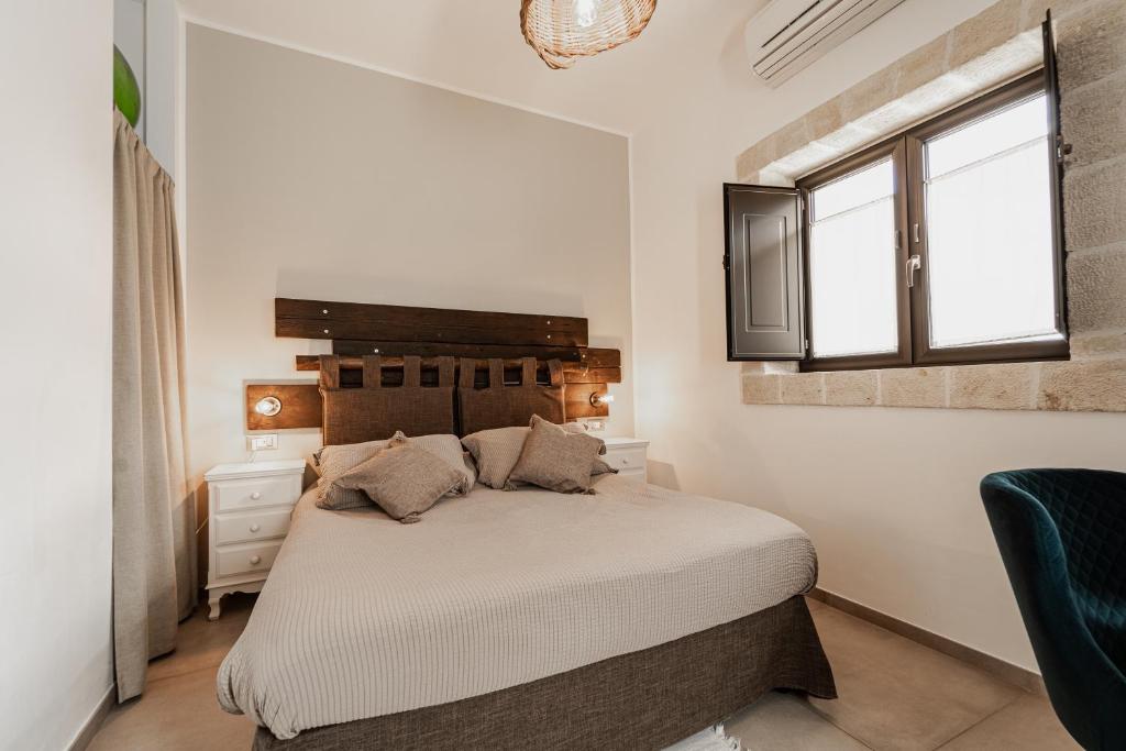 滨海波利尼亚诺Oppure - Masseria Moderna的一间卧室设有一张大床和一个窗户。