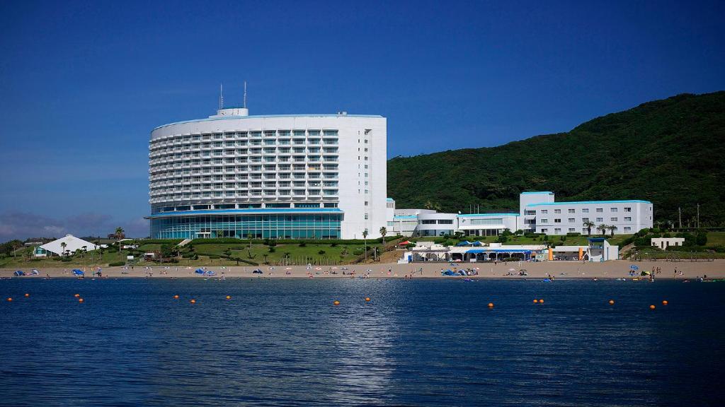 田原市伊良湖度假&会议酒店的海滩上一座大型建筑,拥有海滩和大海