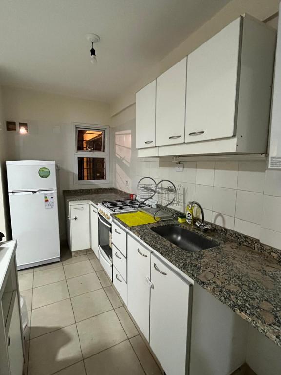 耶尔瓦布埃纳Departamento con excelente ubicación的厨房配有白色橱柜、水槽和冰箱。