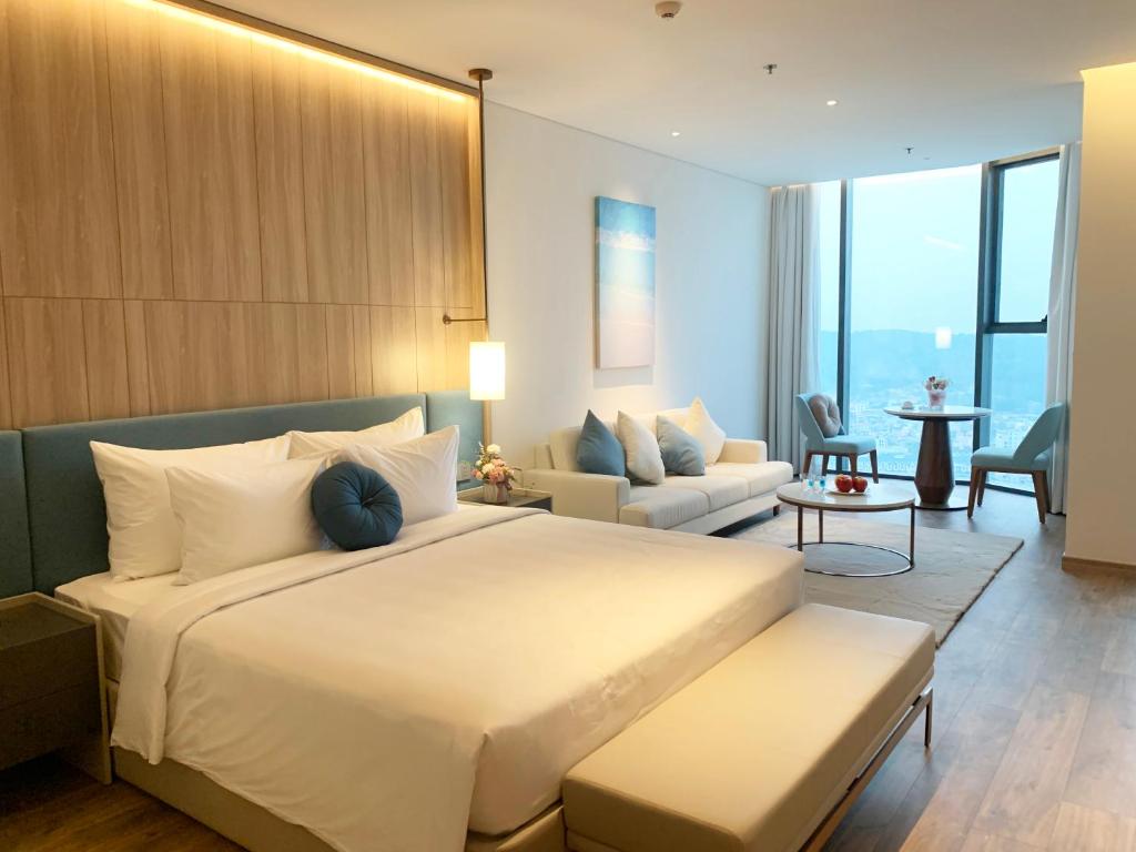 下龙湾HB Serviced Apartment - Alacarte Hạ Long的一间带大床的卧室和一间客厅