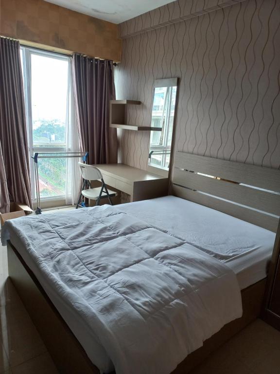 庞多克辛纳J Room的一间卧室配有一张床、一张书桌和一个窗户。