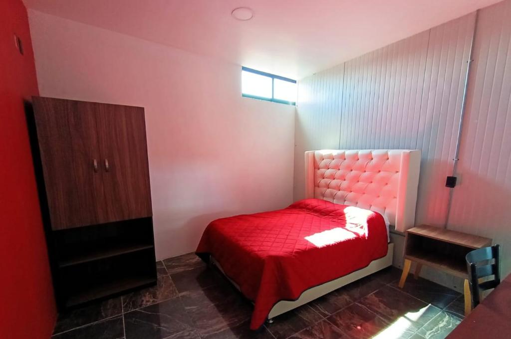 TlatlauquitepecSuite Aries的一间设有红色床和橱柜的小卧室
