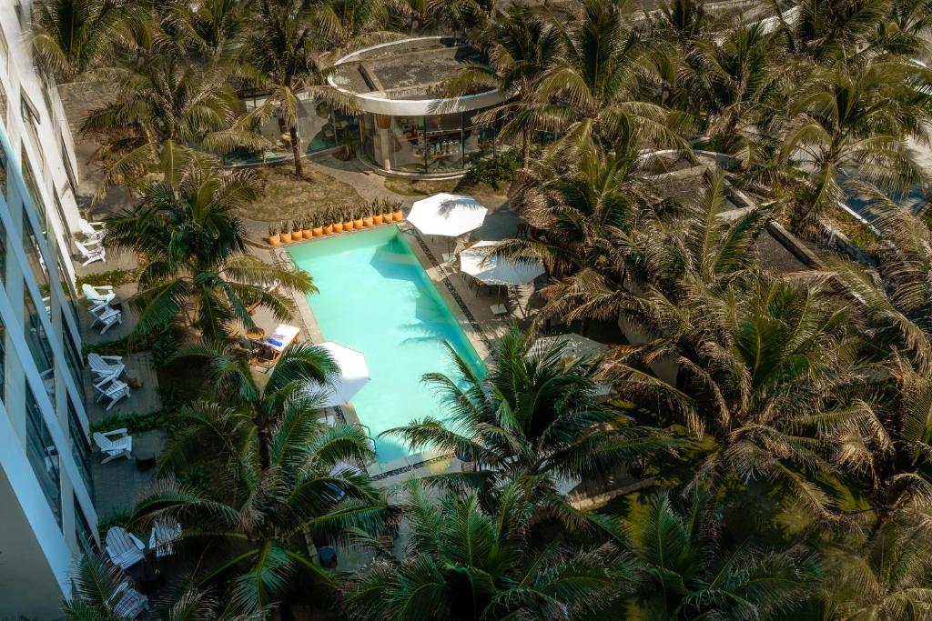 绥和市Sala Tuy Hoa Beach Hotel的棕榈树度假村泳池的空中景致