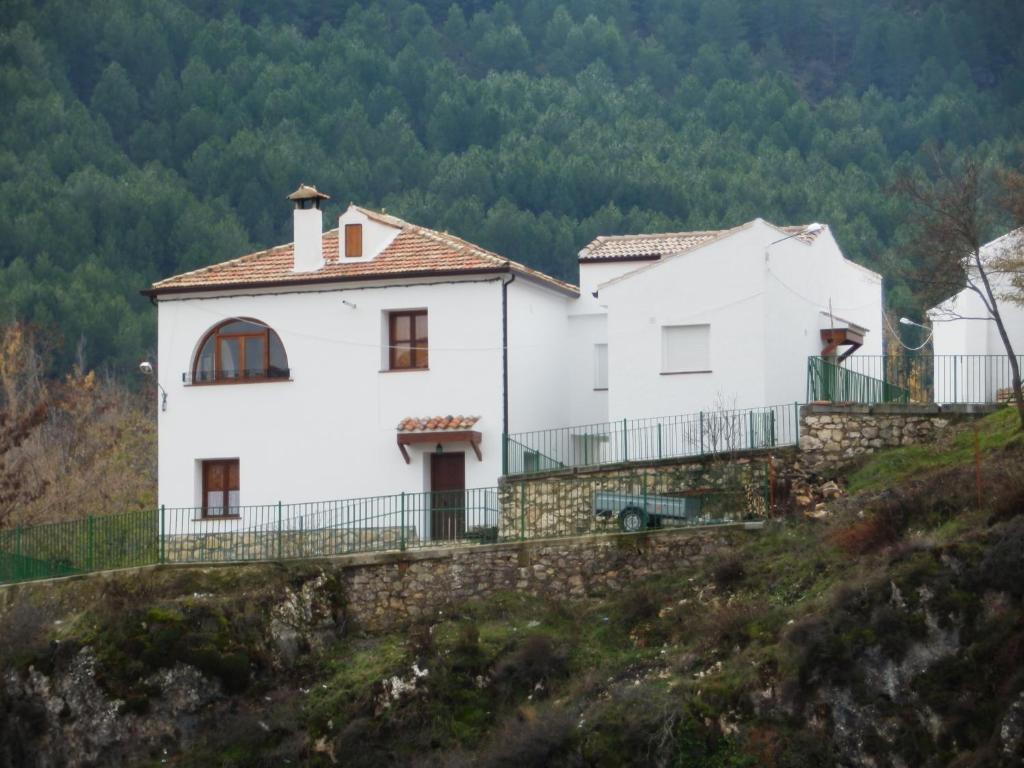 蓬托内斯Casa Rural El Perchel的两座白房子,位于一座小山上,有树木