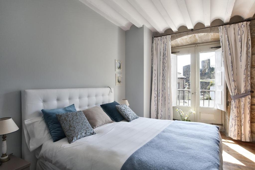 布里纳斯霍斯德布里尼亚斯酒店的卧室配有带蓝色枕头的大型白色床
