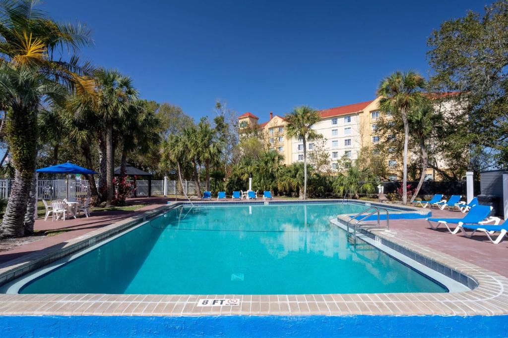 莱克兰莱克兰温德姆旅程住宿酒店的一个带椅子的大型游泳池和一间酒店