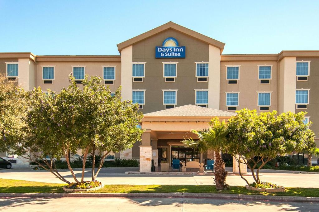 圣安东尼奥Days Inn & Suites by Wyndham San Antonio near Frost Bank Center的享有酒店正面的树木景色