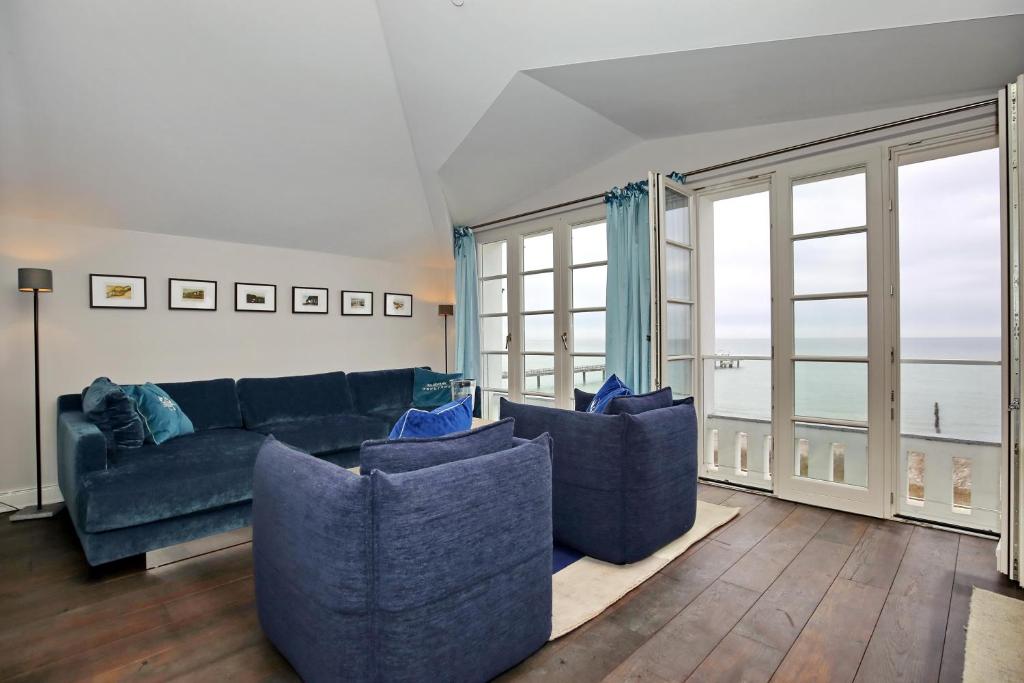 海利根达姆Villa Greif Wohnung 05的客厅设有蓝色的沙发和大窗户