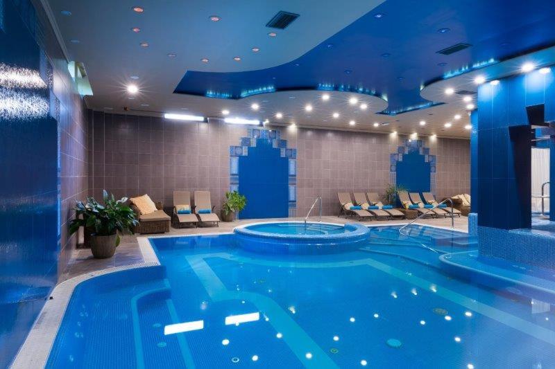 杰尔Golden Ball Club的蓝色天花板的酒店客房内的大型游泳池