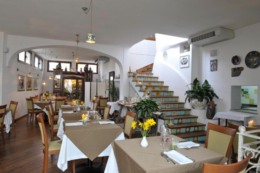 奥罗塞伊Hotel Su Barchile的一间带桌椅的餐厅,以及楼梯