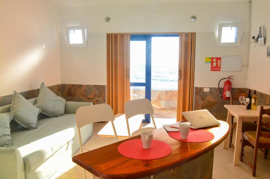巴列埃尔莫索Apartamentos Playa Azul的客厅配有沙发和带笔记本电脑的桌子