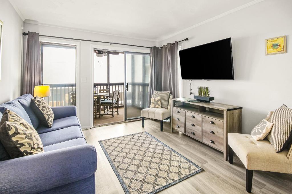 默特尔比奇Seascape 109的客厅配有蓝色的沙发和电视
