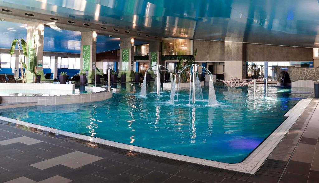 巴亚马雷Primera Dru Hotel&Spa的一座建筑中一个带喷泉的游泳池