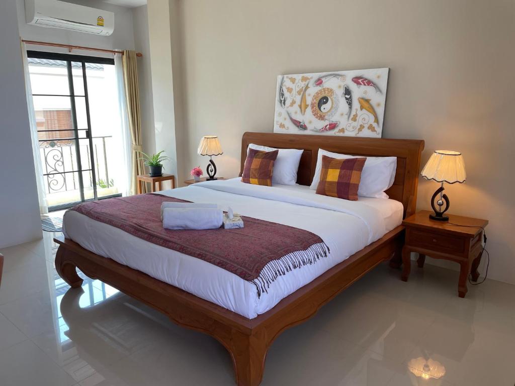 清迈Laph Kham House的一间卧室配有一张大床、两盏灯和一个窗户。