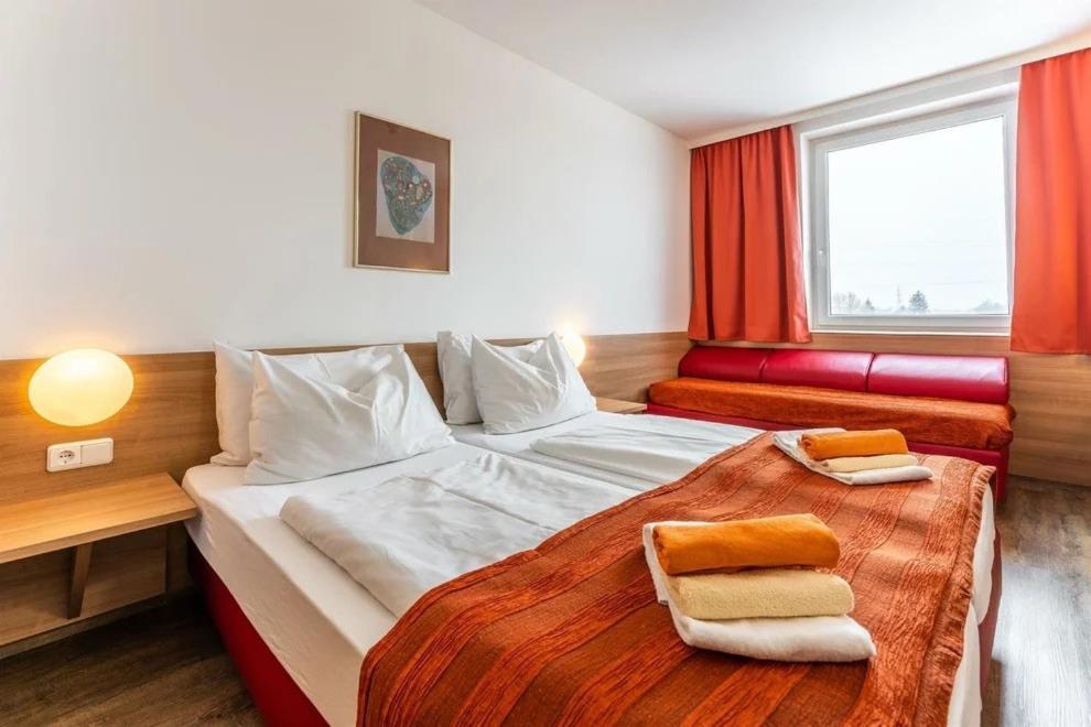 萨尔茨堡萨尔茨堡展览中心酒店的一间卧室配有一张床,上面有两条毛巾