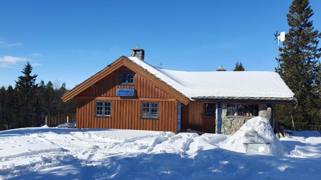 高尔Cozy log cabin at beautiful Nystølsfjellet的前方的小木屋,地面上积雪