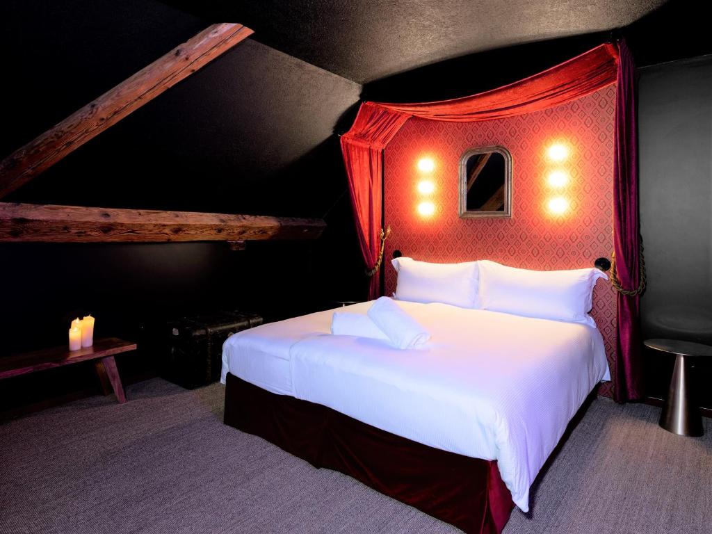 圣于尔萨讷Peanut Medieval Lodge的一间卧室配有一张大白色床和红色天篷