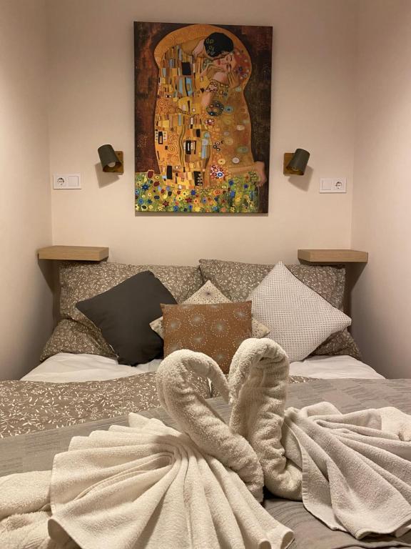 布达佩斯Mrs. Columbo's Flat的一张带毛巾和绘画的床