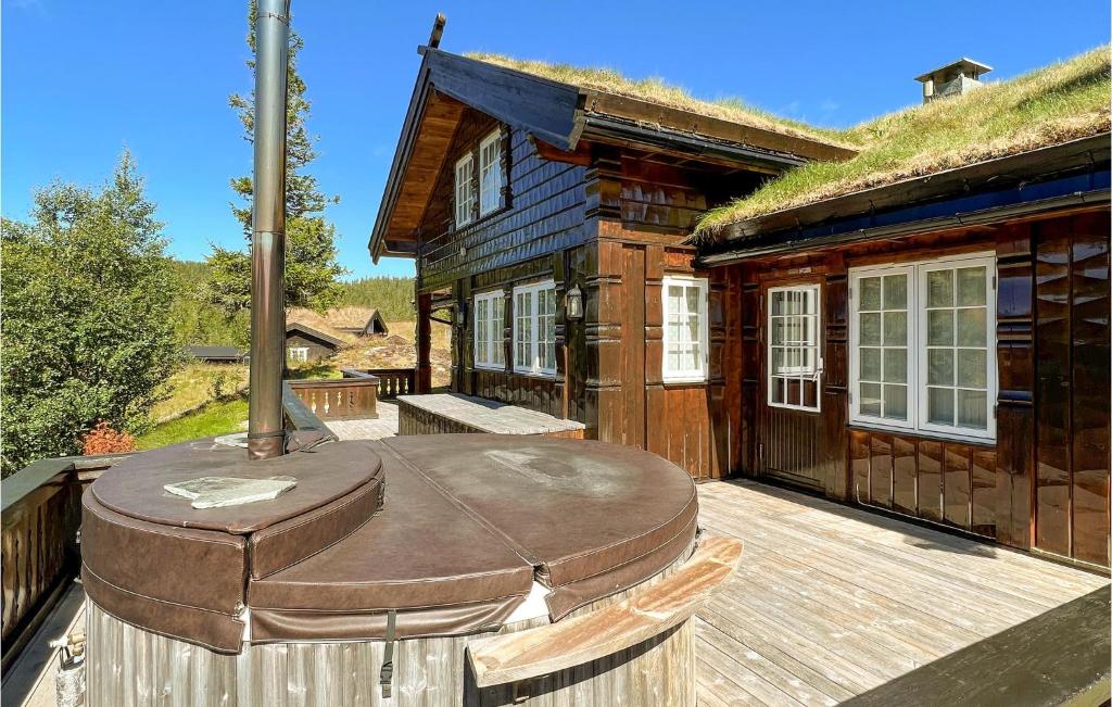 尤坎Amazing Home In Rjukan With Sauna And 5 Bedrooms的小木屋内的大型甲板上设有热水浴池