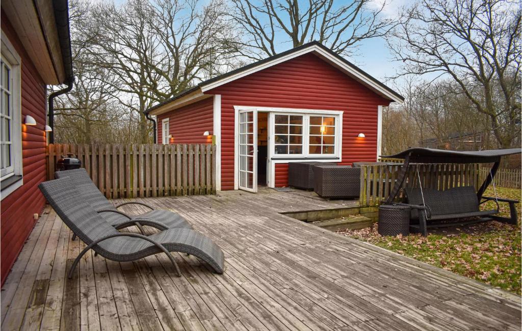 GärsnäsStunning Home In Grsns With Kitchen的木甲板上的长凳,有红色的房子