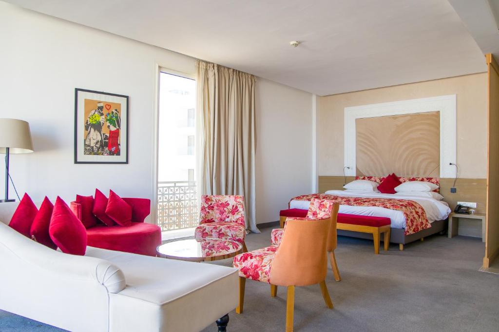 丹吉尔Mandarin Palace Hotel & Spa的酒店客房配有一张床、一张沙发和椅子。