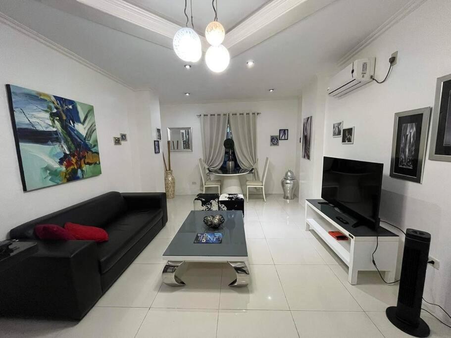 安吉利斯Kandi big 1 BR, king bed, free housekeeping, Wi-Fi的客厅配有黑色沙发和电视