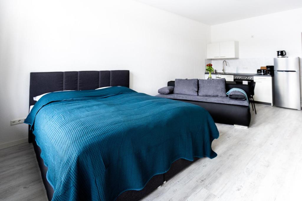约阿希姆斯塔尔Ferienwohnungen direkt am Werbellinsee的一间卧室配有蓝色的床和沙发