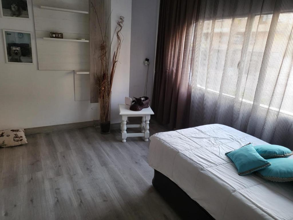 阿瓜杜尔塞Casa Violeta的一间卧室配有一张床、一张桌子和一个窗户。