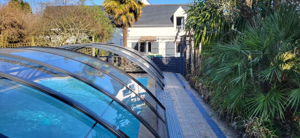 卡纳克Gite Kergroix en Carnac的一座带玻璃屋顶和游泳池的房子