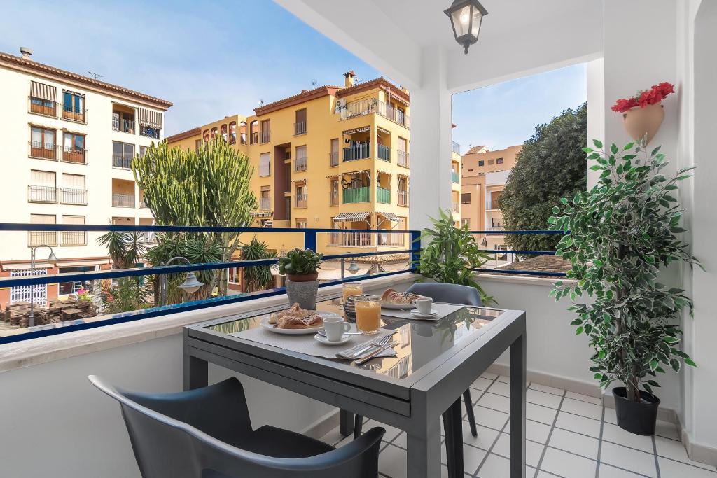 莫莱拉Apartamento mediterráneo en el alma de Moraira的阳台配有桌椅,享有建筑的景致。