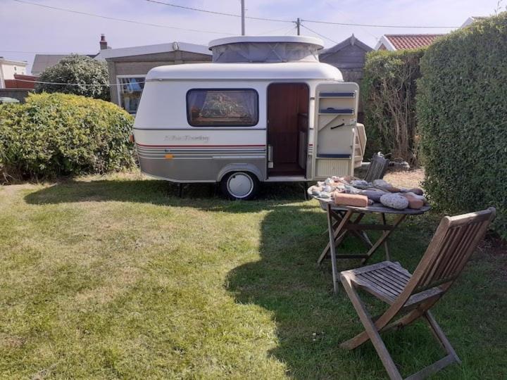 诺里奇Sundial Cottage Eriba Caravan的停放在院子里的带桌椅的大篷车