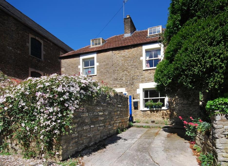 弗罗姆Charming Cottage in the Heart of Frome - Sun House的砖屋,有石墙和鲜花