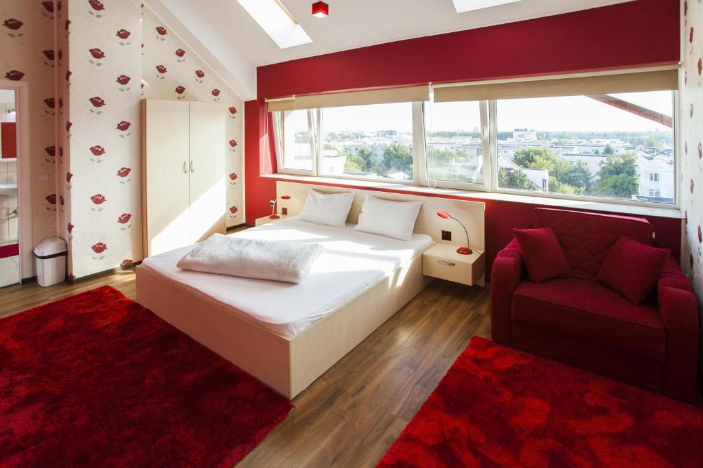 布加勒斯特拉吉尔酒店的一间卧室配有一张床、一张沙发和一个窗口