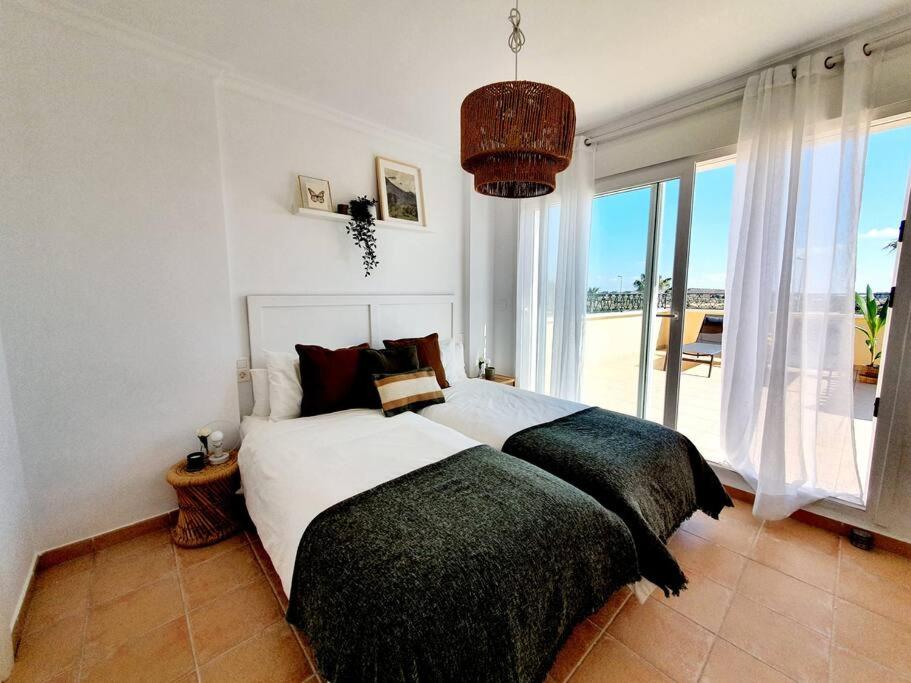 穆尔西亚Dúplex a estrenar 4hab Altaona Golf piscina playa的一间卧室设有一张大床和一个大窗户