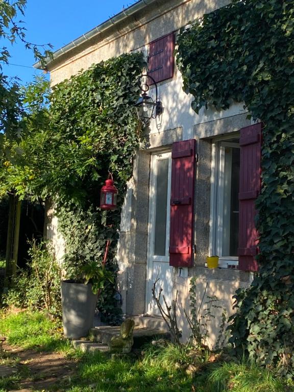 Saint-Martin-du-PuyChambre d'hôtes La Chouette的一座有窗户和植物的房子
