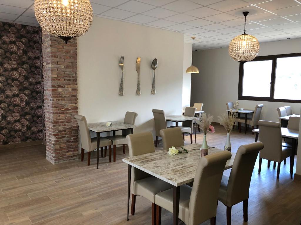 菲斯卡尔Leyendas Del Pirineo的用餐室配有桌椅和吊灯。