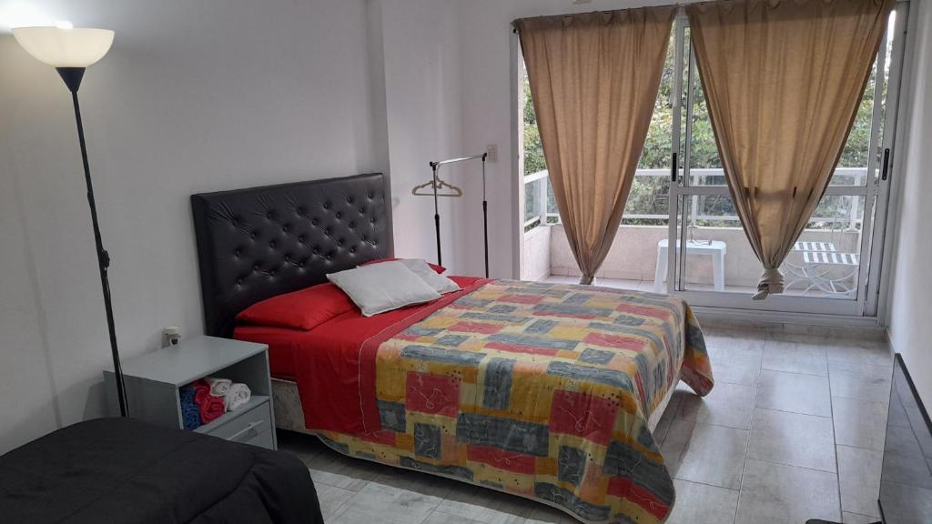 布宜诺斯艾利斯Amplio departamento completo en Caba的一间卧室设有一张床和一个大窗户
