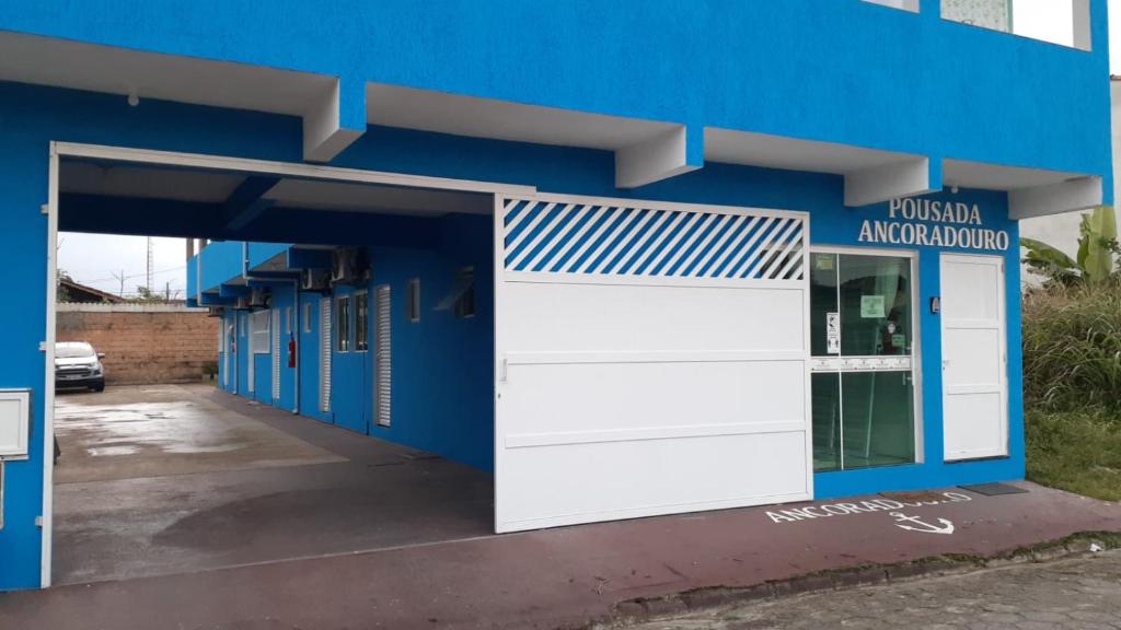 卡纳内亚Pousada Ancoradouro的蓝色的建筑,设有白色的车库门