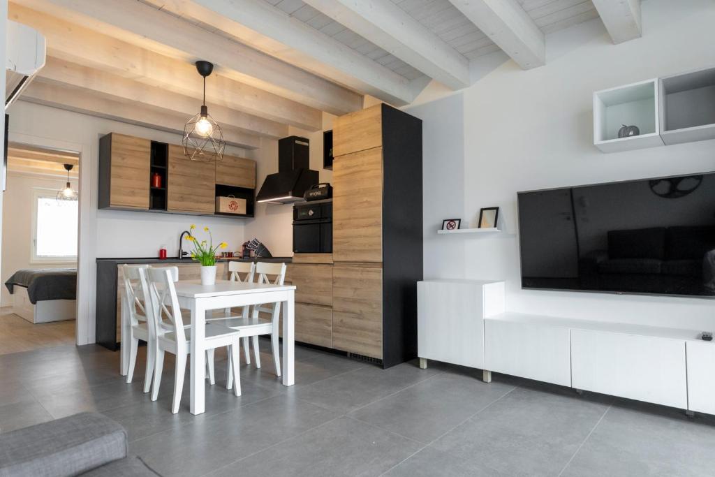 维罗纳Verona Urban Apartment的厨房以及带白色桌椅的用餐室。