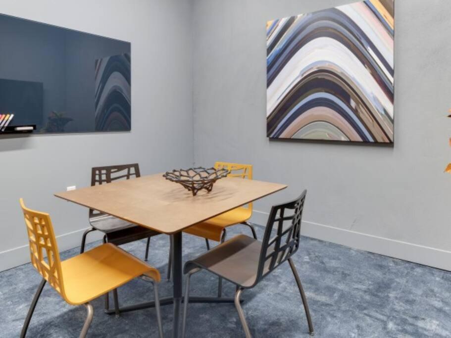 奥克兰Jack London square stylish luxury 1BD apartment的餐桌、椅子和画作