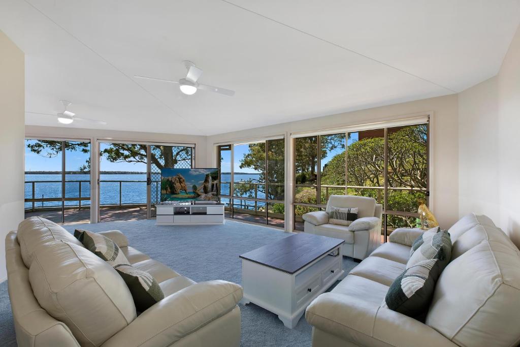 图克雷Sunset Lakehouse的带沙发和电视的客厅以及部分窗户。