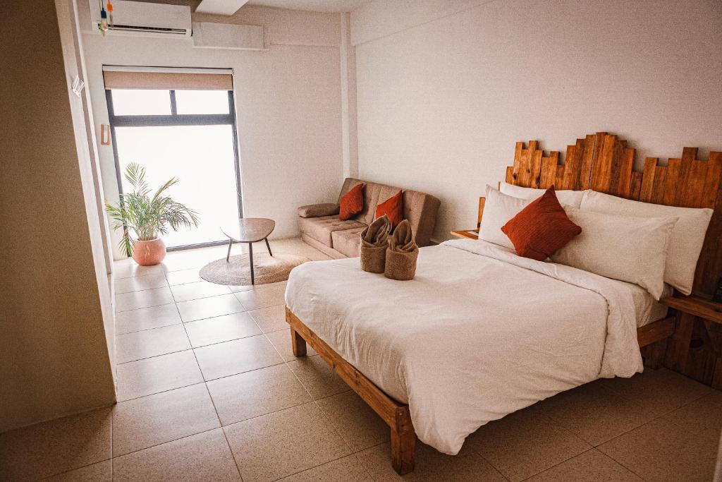 坎昆Nomads Hotel, Hostel & Rooftop Pool Cancun的一间卧室配有一张带鞋的大床