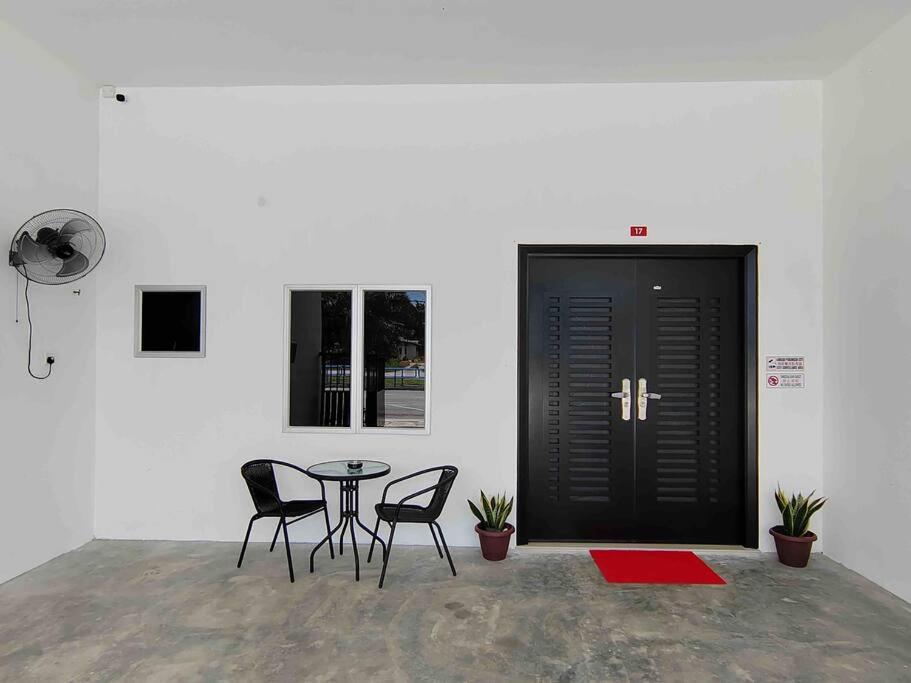实兆远New Single Storey Homestay @ Sitiawan 3R2B (6-9PAX) _Feb Moment Homestay的配有桌椅和黑色门的房间