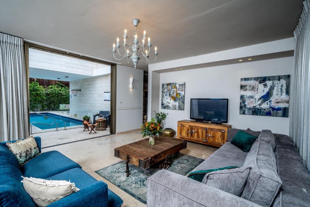 埃拉特Country Villa - Ella Sun的客厅配有蓝色的沙发和电视